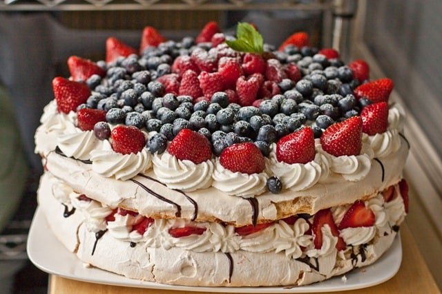 12 inch round gluten free cake recipe topped with whipped cream and berries between each layer.