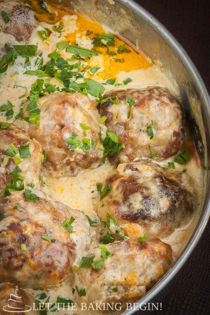 Meatballs simmering in jalapeno cream sauce topped with fresh greens.