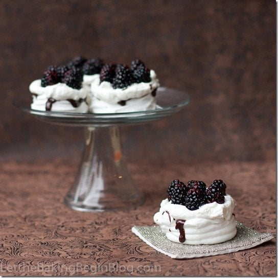 Meringue baskets with Chantilly cream & blackberries on a glass platter. 