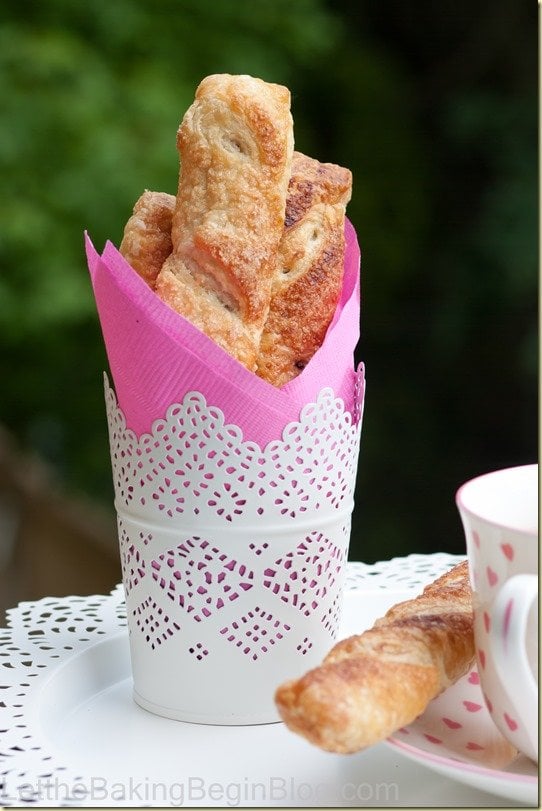 Croissants in a decorative stand next to a pink napkin.