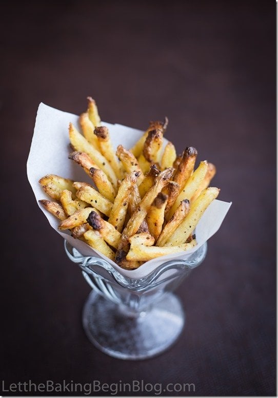 Oven baked fries in a glass cup topped with pepper. 