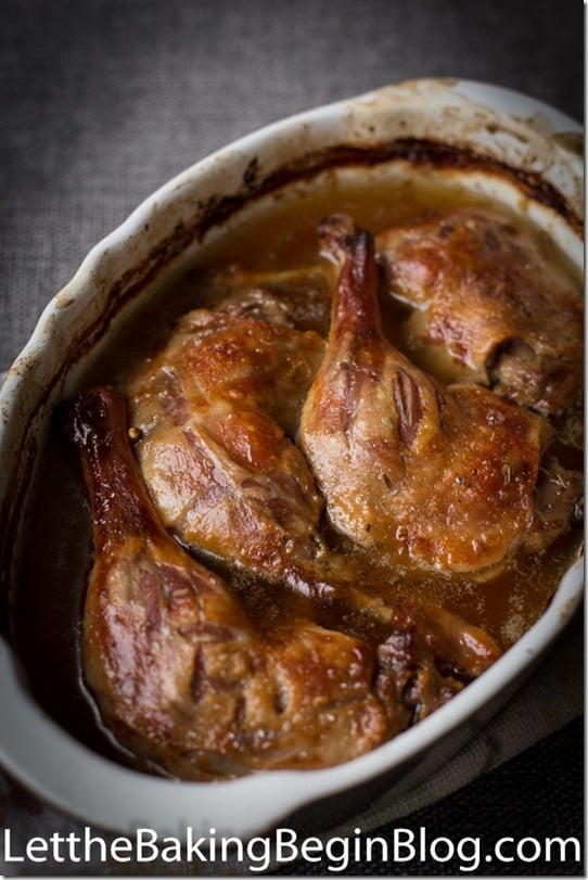 Duck confit in a baking dish on a gray napkin.