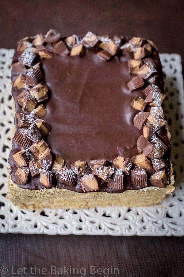No-bake honey cake on a platter topped with chocolate ganache and chocolate candy. 