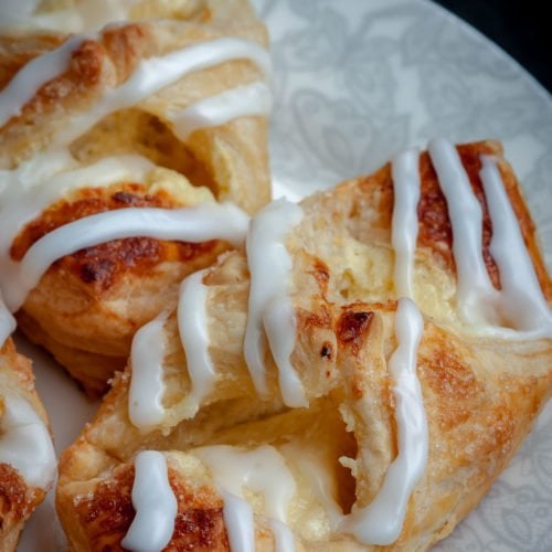 Cheesecake Danish is a puff pastry dessert that's filled with sweet cheesecake filling and drizzled with Lemon Sugar Glaze. Make it once and your family will ask you to make it time and time again. Ready in 30 minutes or less!