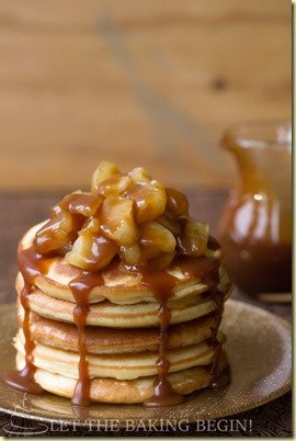 Homemade pancakes stacked on top of each other topped with apple and caramel sauce. 