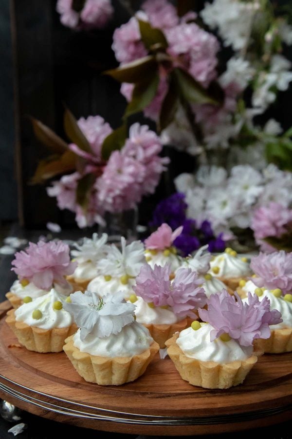 Mini tart recipe - small tarts topped with souflee and fresh flowers on a cake stand.