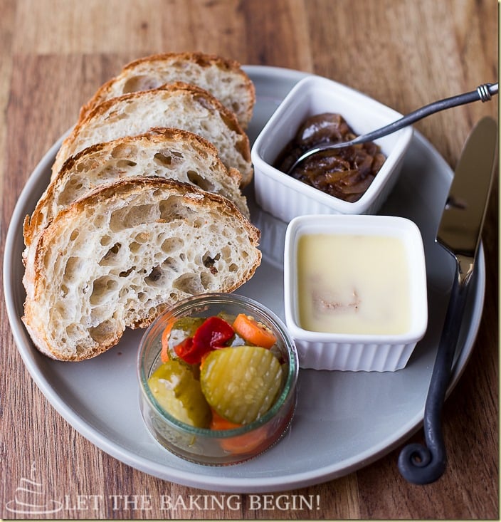 The best chicken liver mousse recipe served next to balsamic onions, vegetables, and bread all in a white plate.