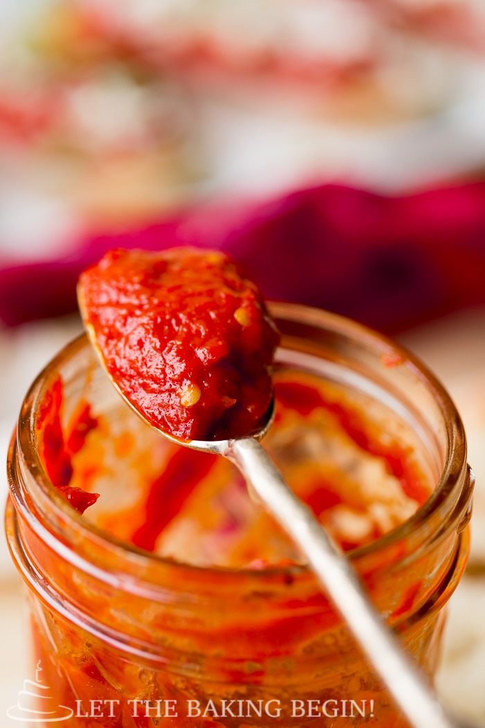 A can of roasted bell pepper spread with a spoonful on top of the jar.