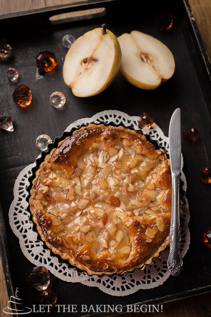 French tart with sliced pear next to it.