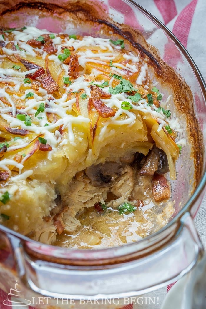 Chicken Mushroom & Potato Casserole in a casserole dish. Topped with cheese, bacon, and greens. 