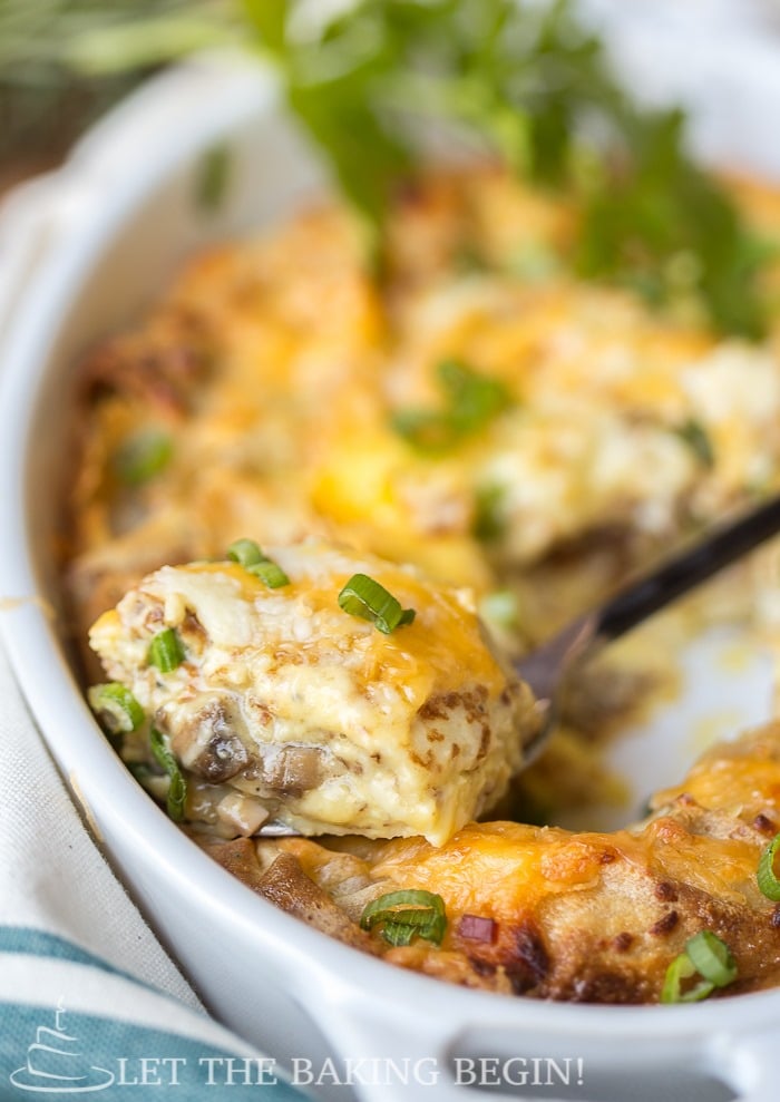 Scoop of stuffed crepe and egg breakfast in a casserole dish topped with fresh greens.