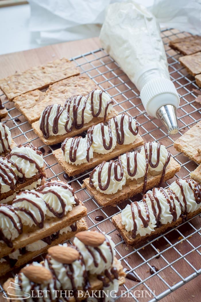 Pastries with mousse cream, drizzle chocolate, and almonds.