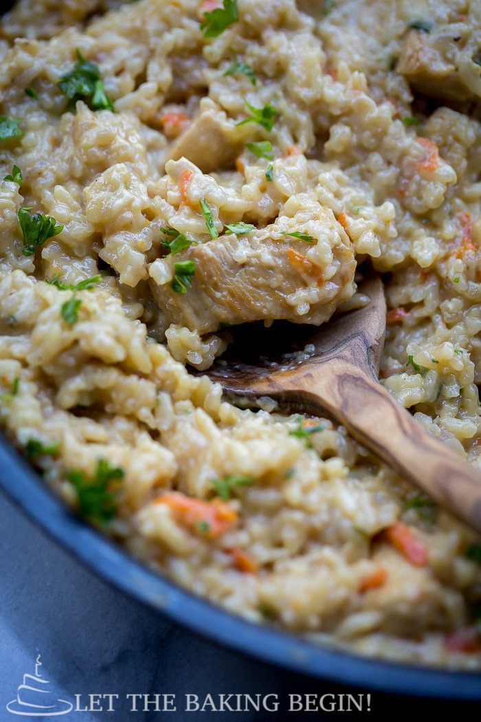 Cheesy chicken and rice dinner in a pot with a wooden skillet. 