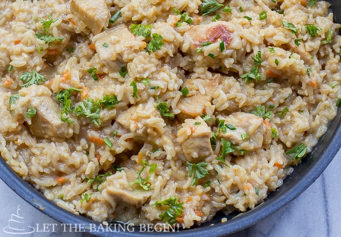 The best creamy chicken & rice one pan dinner in a bowl topped with fresh greens. 