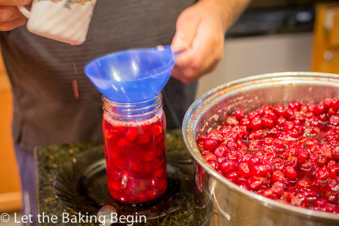 How to use a canning funnel scoop to fill up mason jars with cherries and cherry juice.
