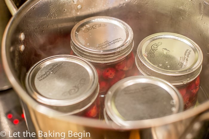 Closed mason jars in a pot in boiling water.