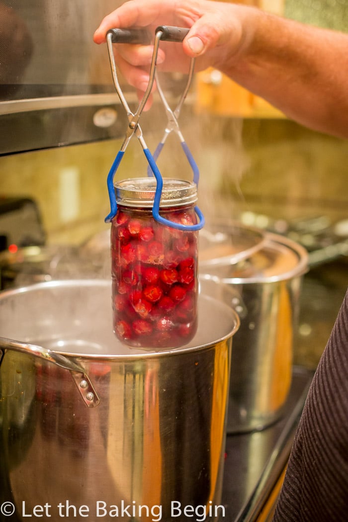 Canned cherries being pulled from boiling water.