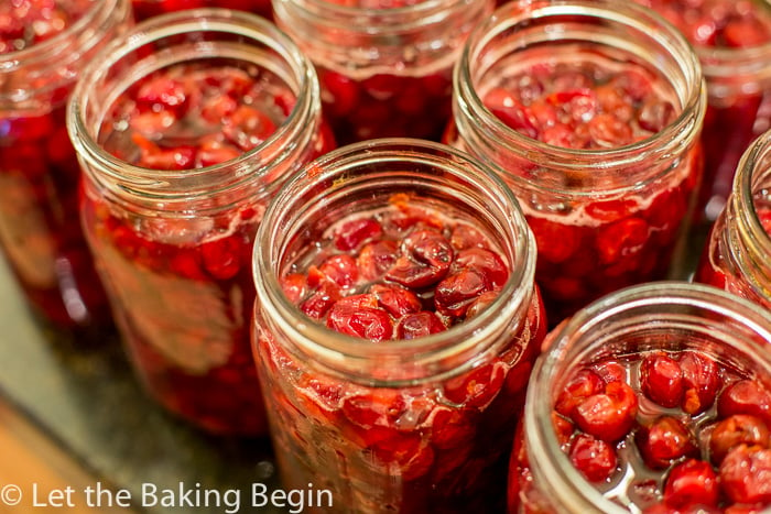 Mason jars filled with cherries and cherry juice.