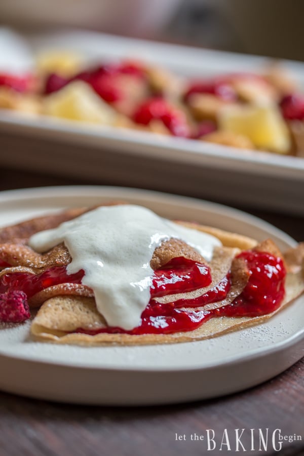 Crepes topped raspberry and strawberry jam and sweetened sour cream.