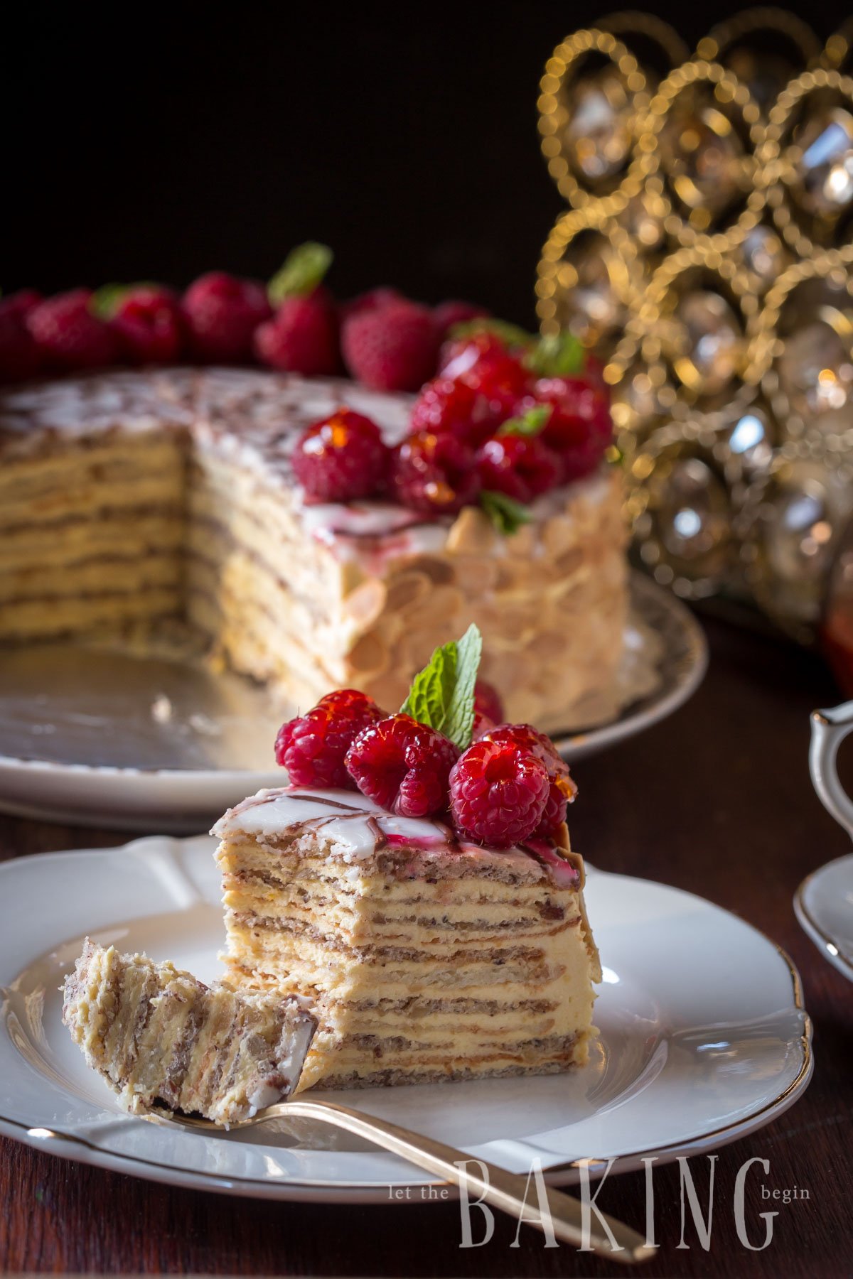 A slice of Esterhazy cake on a plate with a spoonful of cake. 