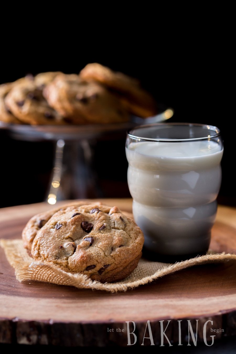 The best cookie recipe stacked on top of each next to a glass of milk. 