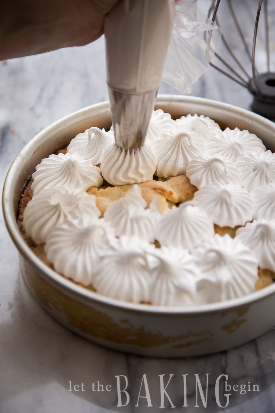 A pirog in a baking sheet topped with a basic meringue. 