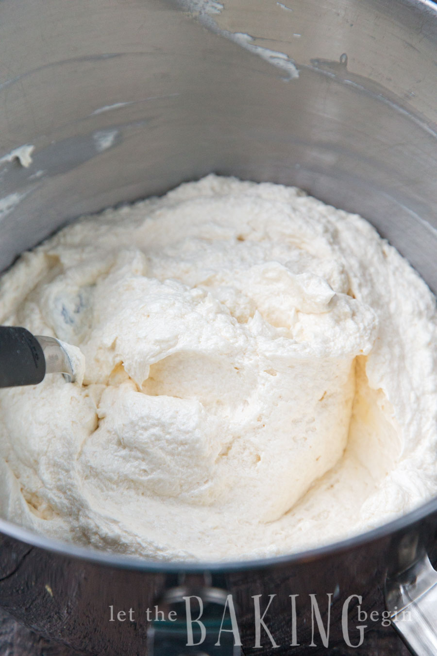 Russian Buttercream, or buttercream made of just butter and sweetened condensed milk in a metal mixing bowl.