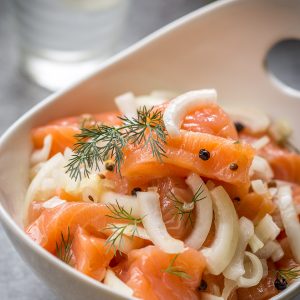 Cured Salmon is a cross between a lox and gralvax. It is brined in a salty-sweet brine with spices and eaten in chunks with a hot baked potato.