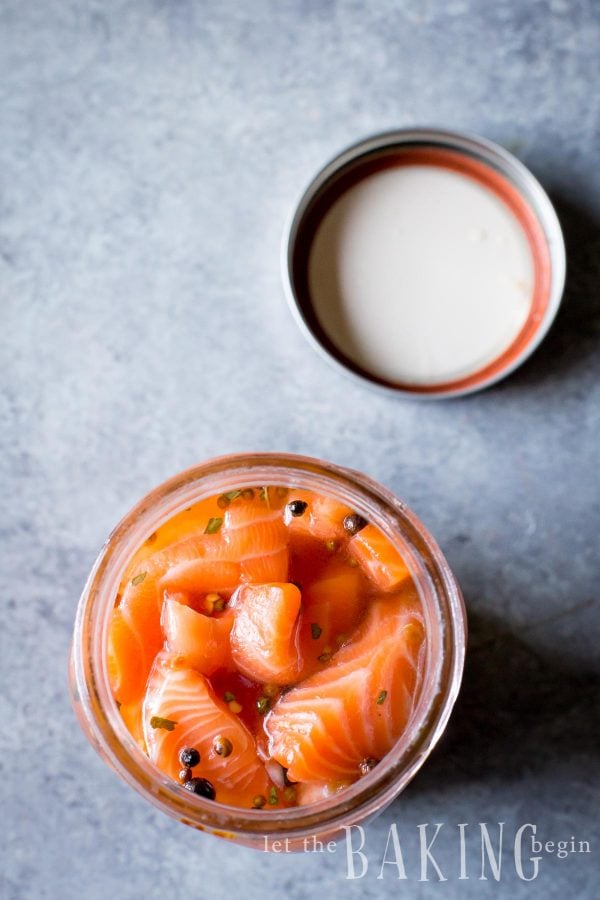 Top view of salmon with peppers in a mason jar.