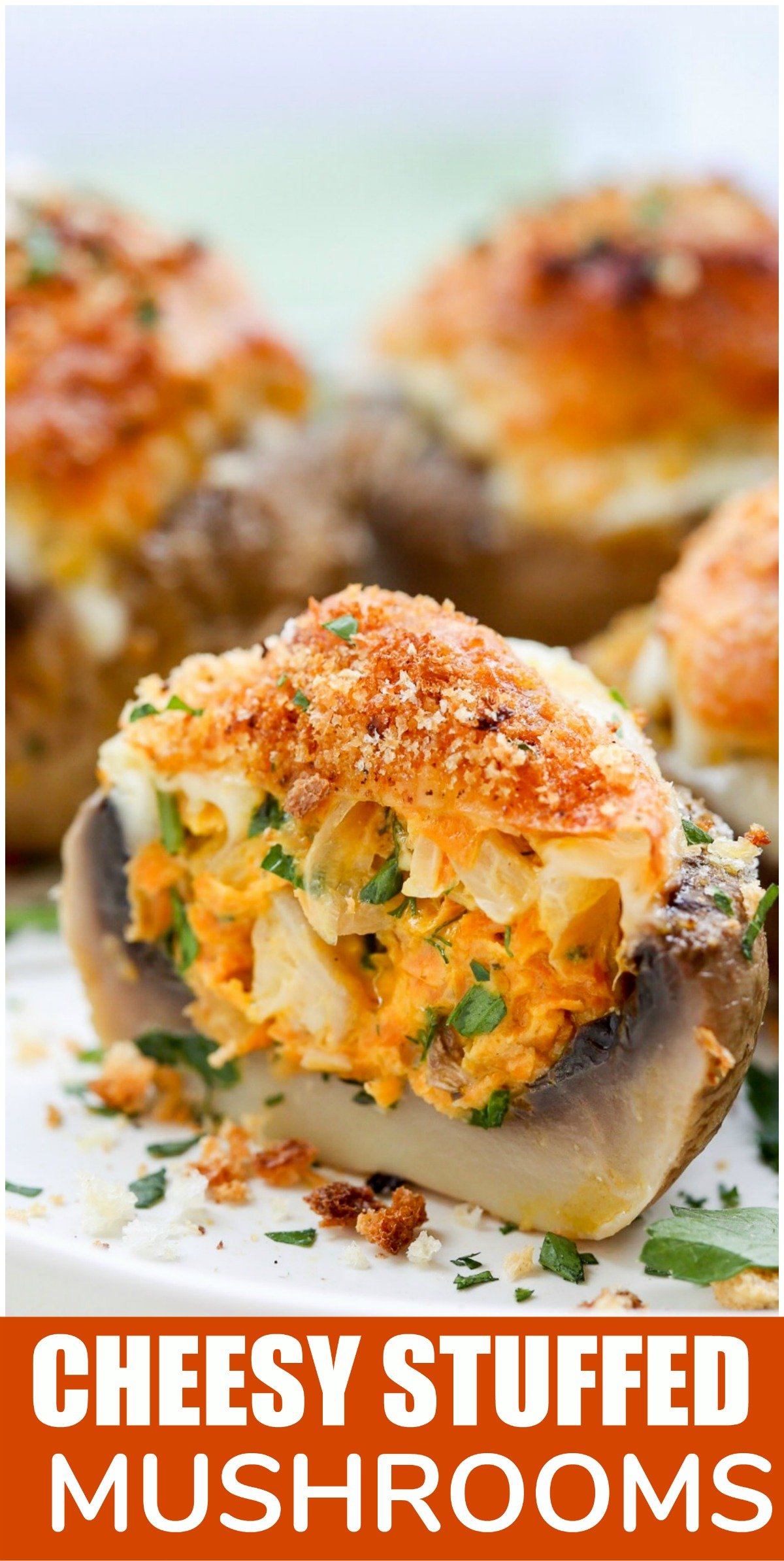 Cheesy stuffed mushrooms topped with fresh greens on a white tray. 