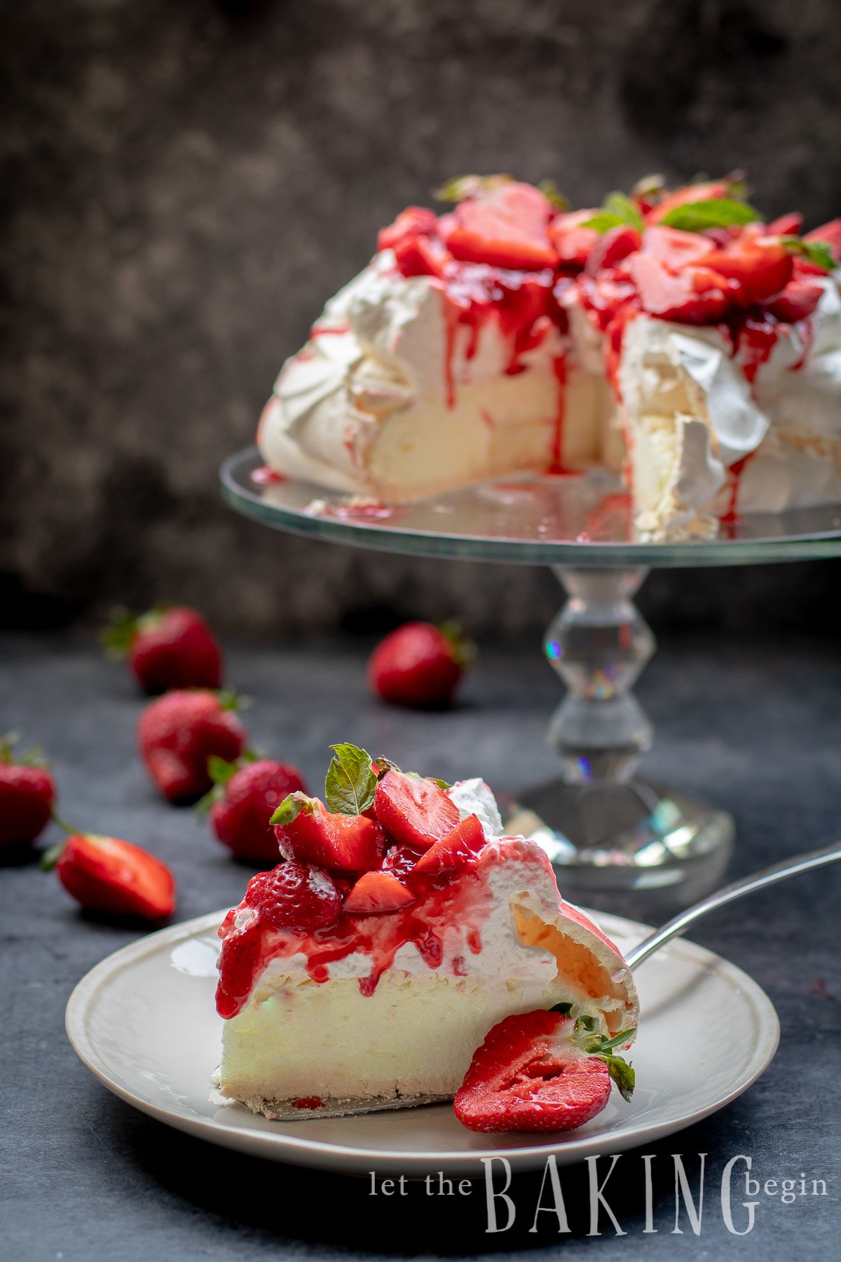 A slice of Pavlova on a plate, with the whole cake in the background.
