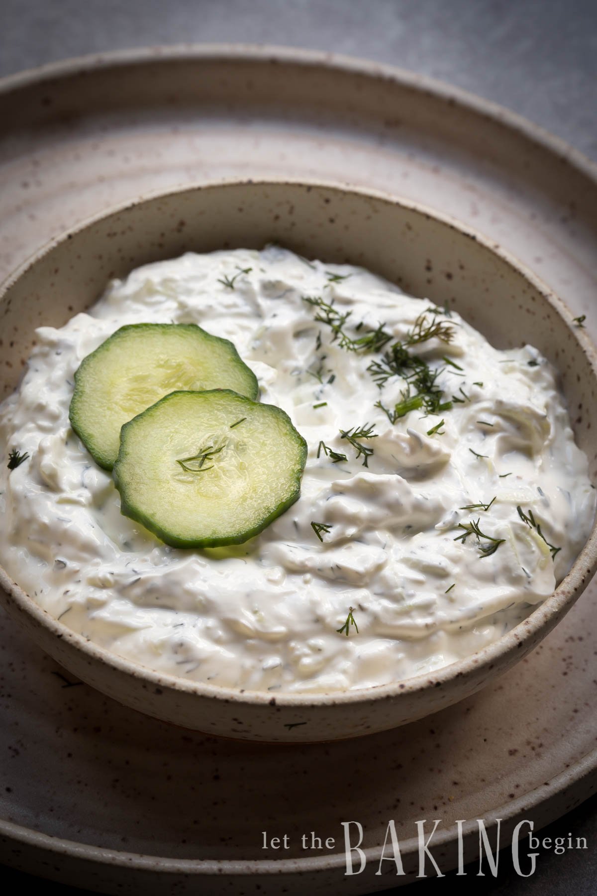 Tzatziki sauce with greek yogurt, cucumbers and dill in a stone bowl.