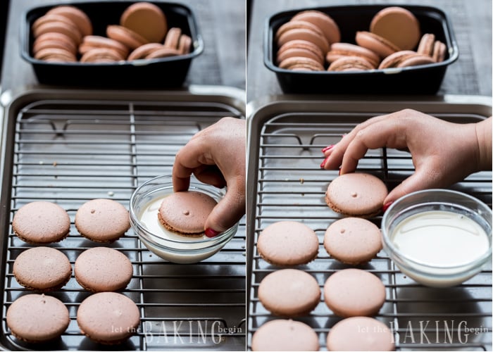 White Chocolate Raspberry Macarons - dipping bottoms of macarons to speed up maturation. Read the post for all secrets to macaron baking.