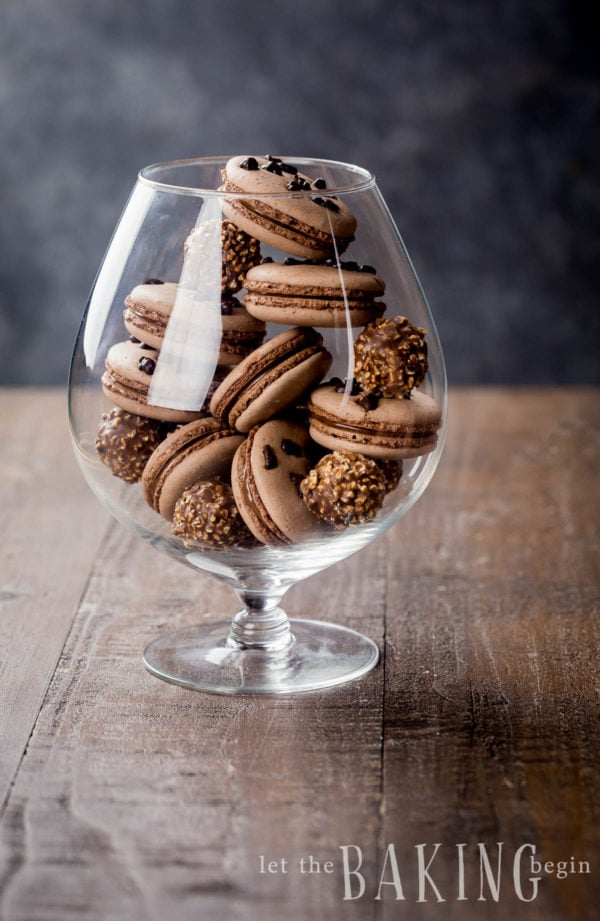 Large footed glass with hazelnut macarons within it.