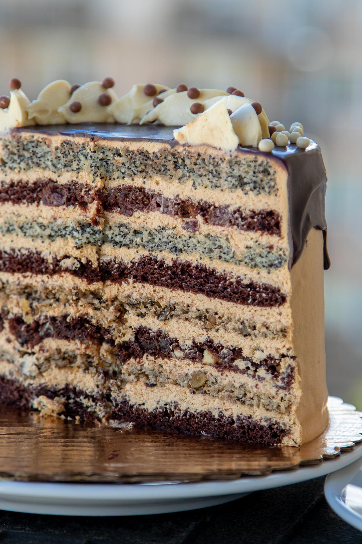 Russian Royal Cake is made with walnut, poppyseed, cherry and chocolate cake layers frosted with Dulce De Leche Buttercream then drizzled with Chocolate. Also known as Korolevskiy Cake this Russian Cake is voted the most favorite cake in my family.
