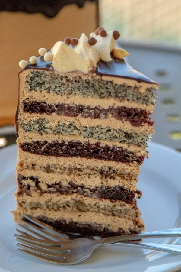 Russian Cake (Korolevskiy Cake)- Layers of walnut, poppyseed, cherry and chocolate cakes frosted with Dulce De Leche Buttercream and drizzled with chocolate.