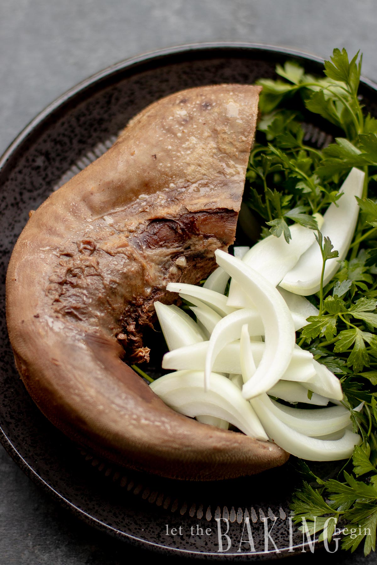 Cooked beef tongue with sliced onions and herbs