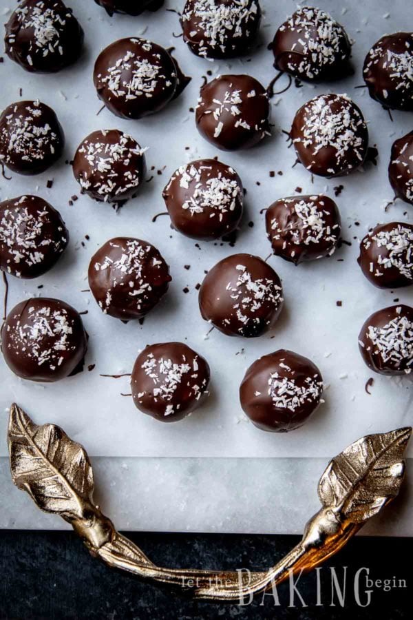 Chocolate coconut balls on white parchment paper.