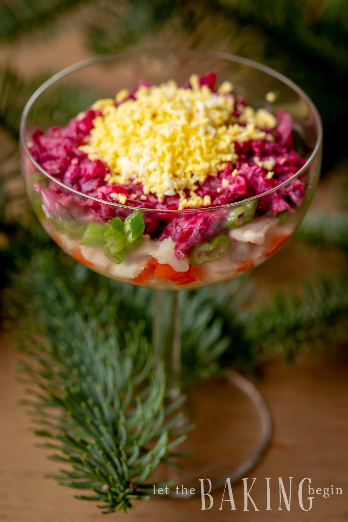 Layered beet salad without mayonnaise in a glass cup.