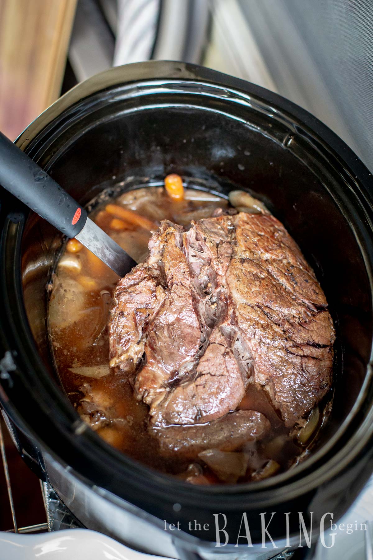 Roast and juice in pot roast with a ladle.
