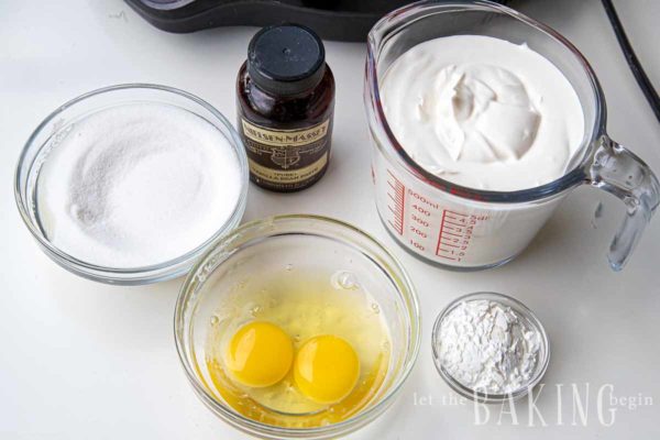 Ingredients for the sour cream buttercream for a Spartak cake such as sugar, eggs, vanilla, and sour cream. 