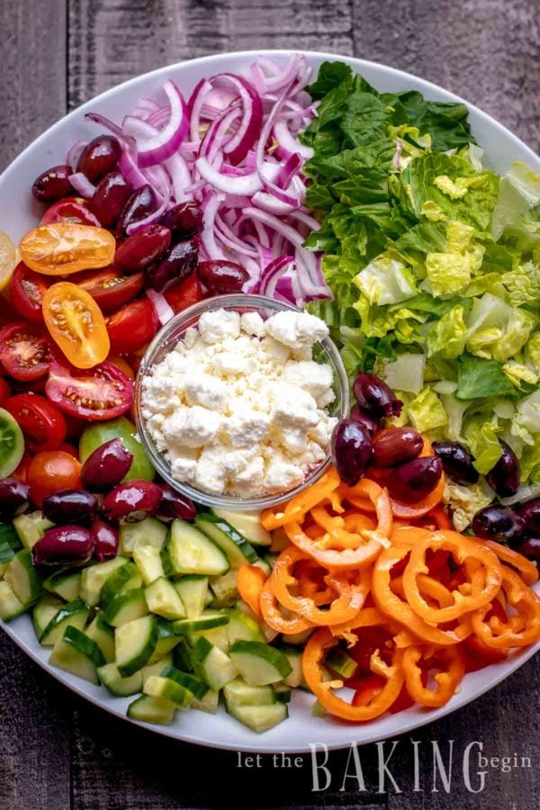 Deconstructed greek salad with lettuce, olives, bell peppers, cucumber, tomato, onion and feta cheese