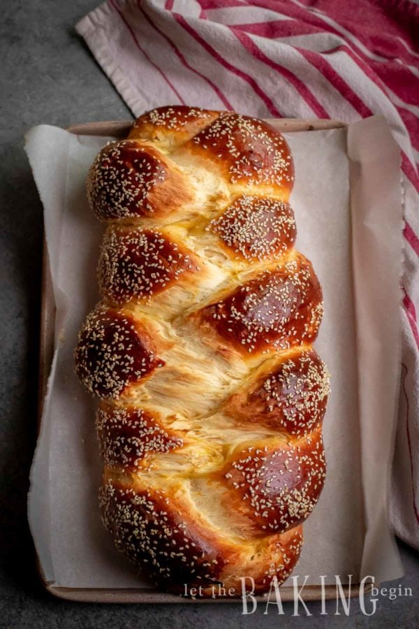 Sweet Bread Braid sprinkled with sesame seeds on a baking sheet. 