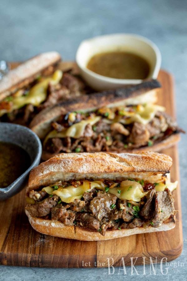 French dip recipe made and cut into several sections on a wooden cutting board