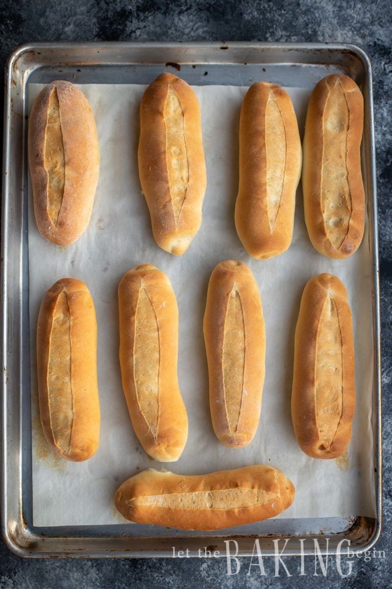 A tray of baked homemade hoagie rolls cooling after coming out of the oven
