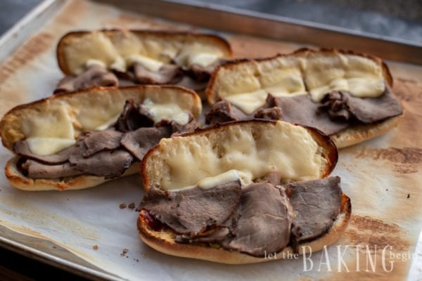 Sandwich rolls topped with roast beef and melted cheese