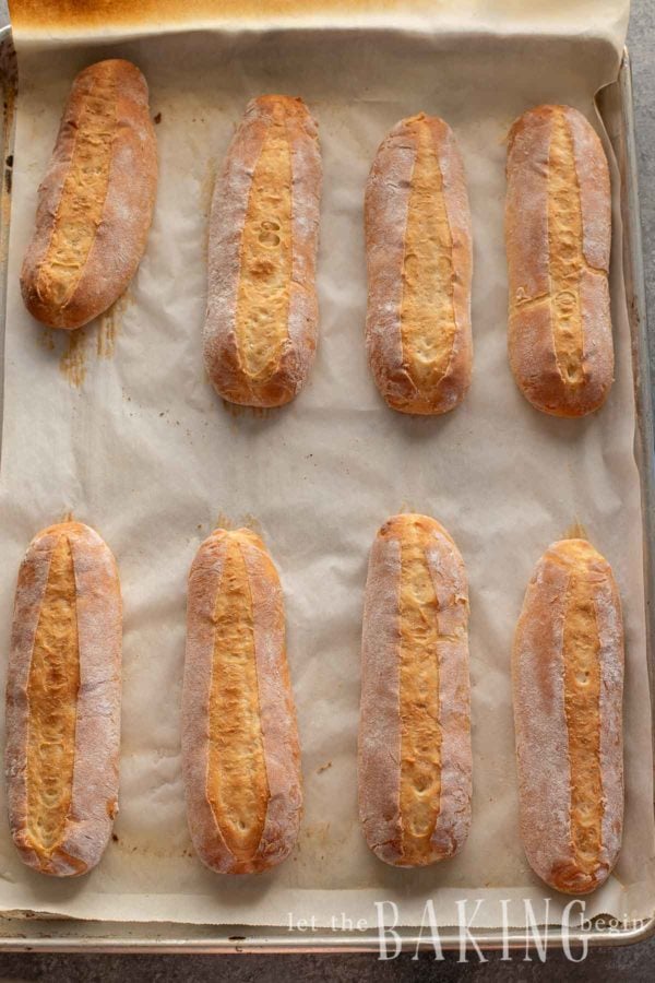 Hoagie rolls fresh out of the oven on a baking sheet