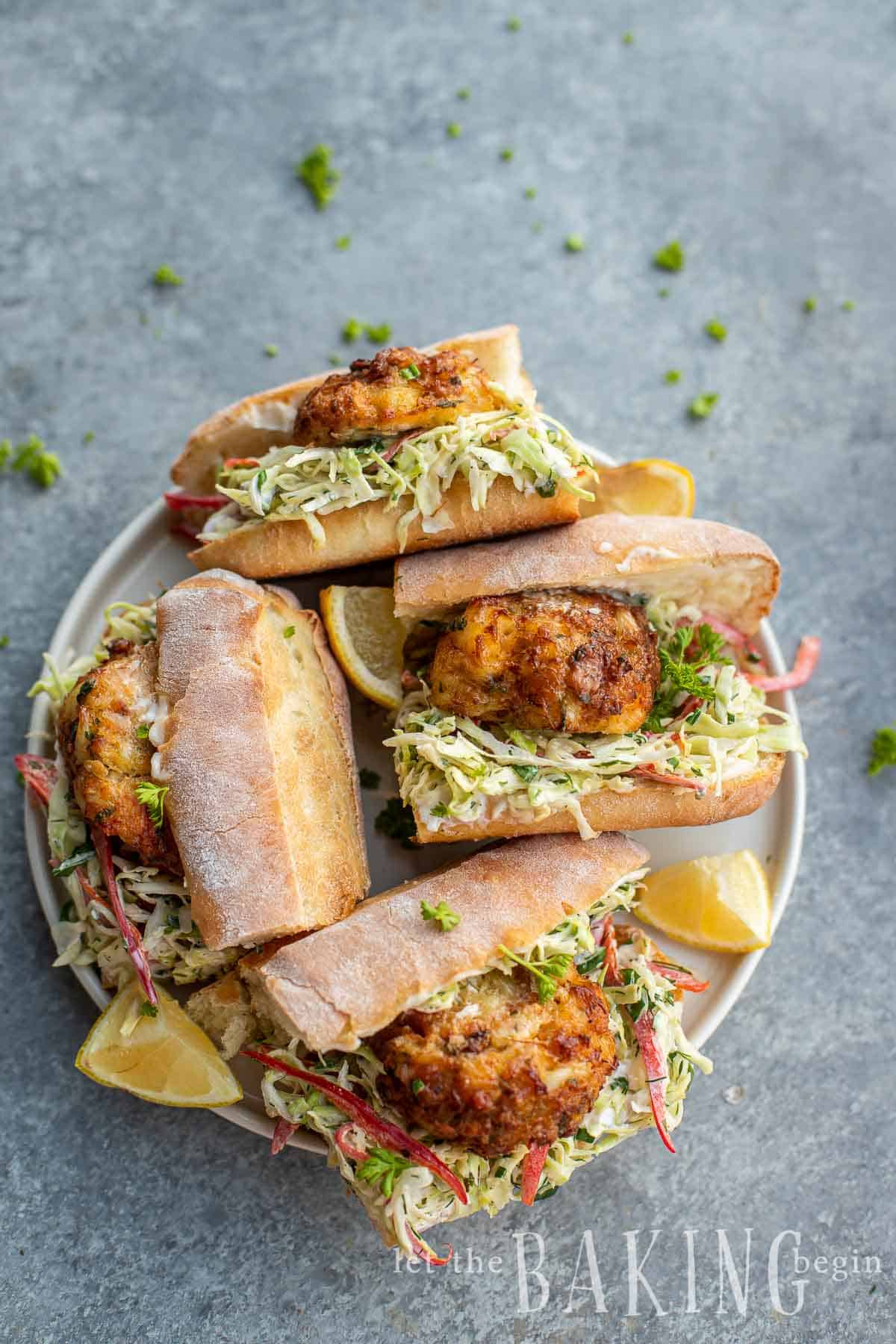 Crab cake sandwiches piled in a plate. 