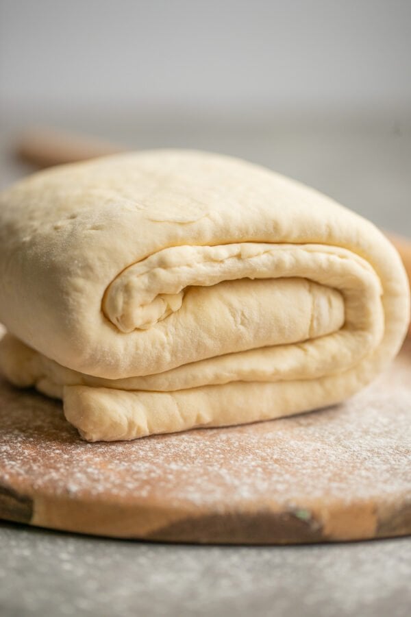 folded quick puff pastry dough on a wooden round