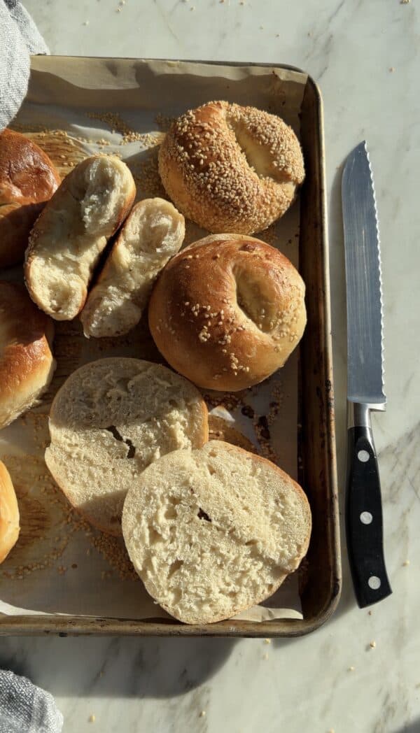 Bagel dough left to rise overnight on the counter, baked and cut open to show a soft, open crumb instead of a chewy one
